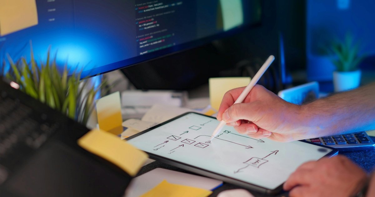 Hands Writing Notes for Coding Project at Desk